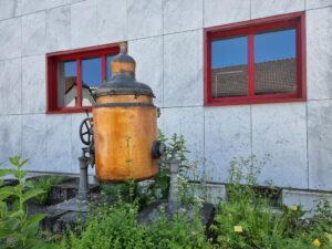 Appenzeller Bitter Destilleriekessel vor Kräutergarten